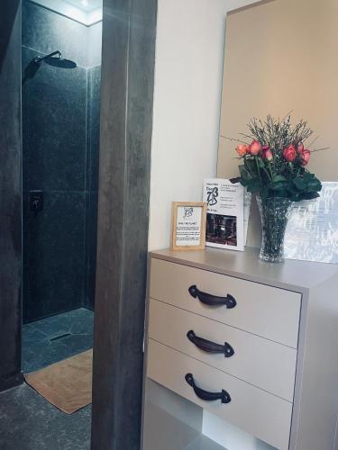 a bathroom with a dresser with a vase of red roses at Riad Dar 73 in Marrakech