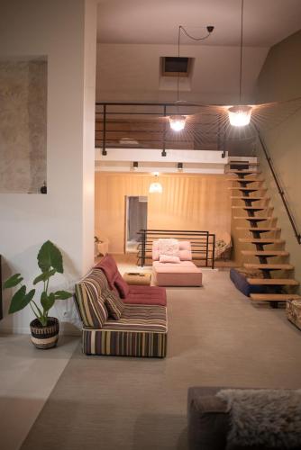 un salon avec un canapé et un escalier dans l'établissement Maison de village toute équipée, à Arnaville