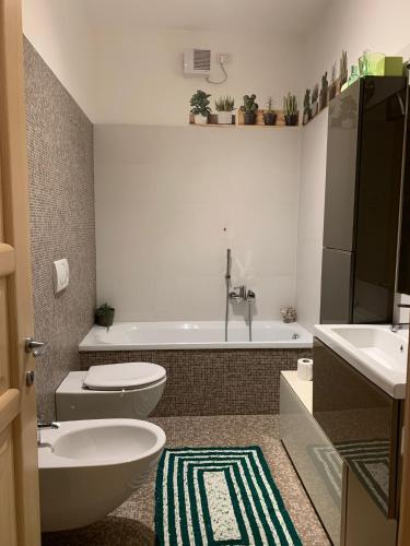 a bathroom with a tub and a toilet and a sink at Appartamento caneve in Arco
