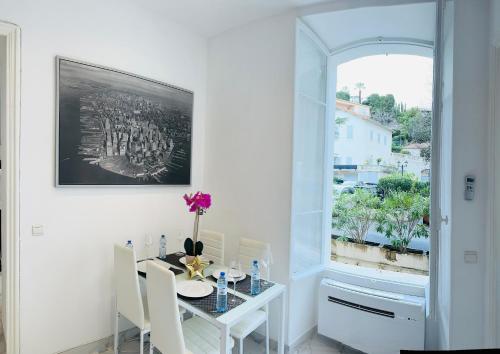 une salle à manger blanche avec une table et une fenêtre dans l'établissement Palais T2 300m de la plage parking en résidence, à Cannes
