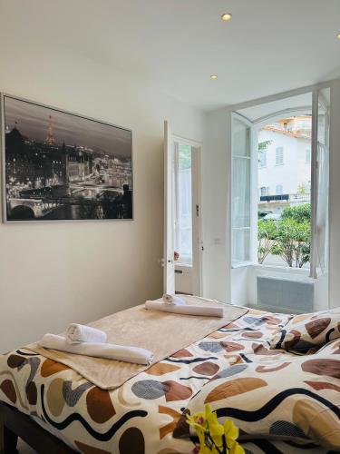 une chambre avec un lit avec un tableau sur le mur dans l'établissement Palais T2 300m de la plage parking en résidence, à Cannes