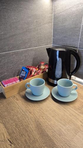 a coffee pot and two cups on a table at Kopaonik Lux Resident Hill Apartman A39 in Kopaonik