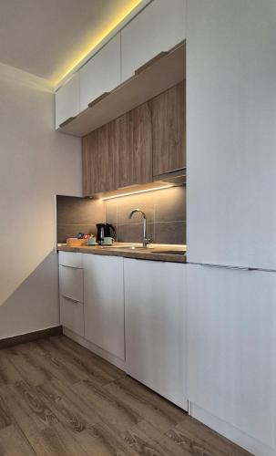a kitchen with white cabinets and a sink at Kopaonik Lux Resident Hill Apartman A39 in Kopaonik