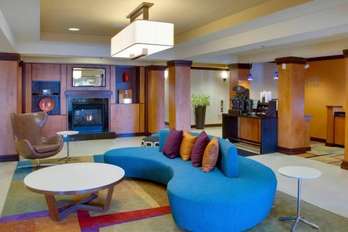 a living room with a blue couch and tables at Fairfield by Marriott Inn & Suites Melbourne West/Palm Bay in Melbourne