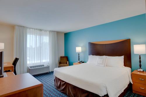 a hotel room with a large bed and a desk at Fairfield by Marriott Inn & Suites Melbourne West/Palm Bay in Melbourne
