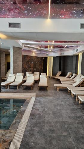 a room with chairs and a pool in a building at Kopaonik Lux Resident Hill Apartman A39 in Kopaonik