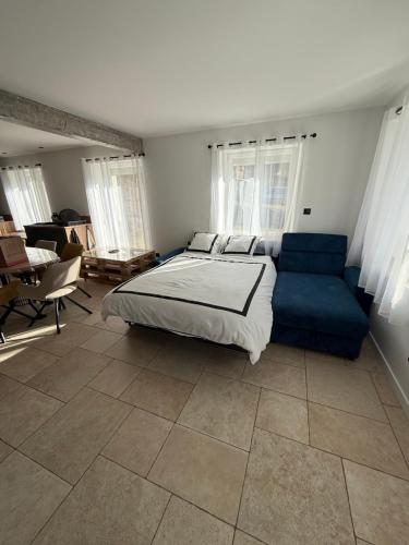 une chambre avec un lit et un canapé bleu dans l'établissement Logement du 162, à Anould