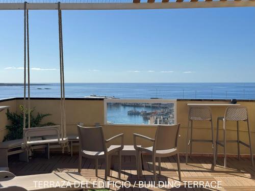 a balcony with a table and chairs and the ocean at Apartamentos Ohana - Edificio Tonillo in Los Cristianos