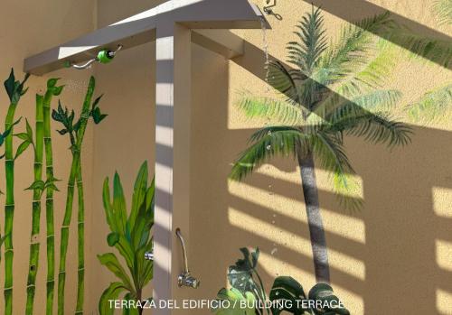 a shadow of a palm tree on a wall at Apartamentos Ohana - Edificio Tonillo in Los Cristianos