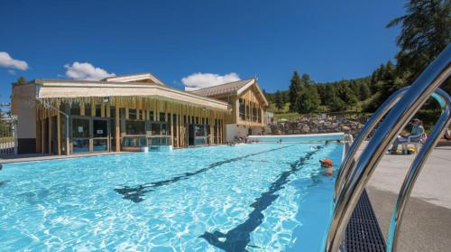 une grande piscine devant un immeuble dans l'établissement RESIDENCE ANTARES 4*, à Risoul