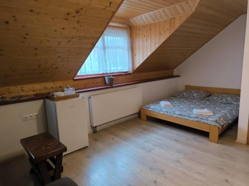 a bedroom with a bed and a window in a attic at Penzion Pod Chřiby in Zdounky