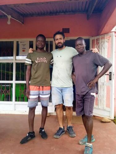three men are standing in front of a house at Mount Mulanje Stopover in Peremwe