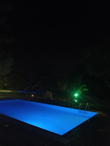 a swimming pool lit up at night at Yala Peace Cottages in Tissamaharama