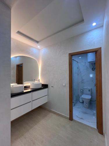a bathroom with two sinks and a toilet at Villa familiale avec piscine in Agadir