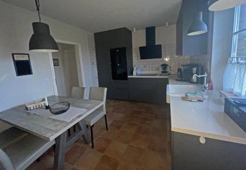 a kitchen and dining room with a table and chairs at Pinswin in Utersum