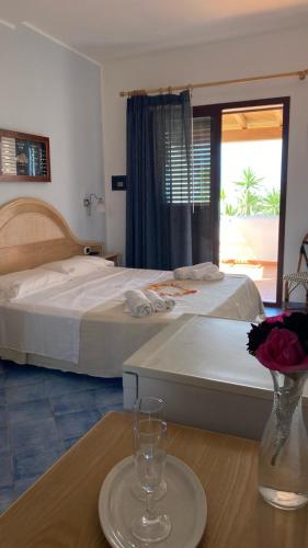 a hotel room with two beds and a table with a vase at LE VILLETTE di CALA MADONNA in Lampedusa