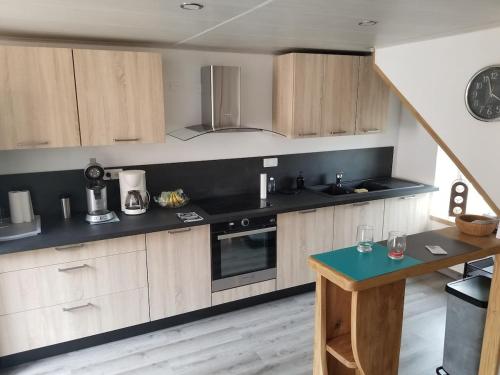 a kitchen with wooden cabinets and black counter tops at Grand Gîte grande capacité dans l'Allier in Loddes