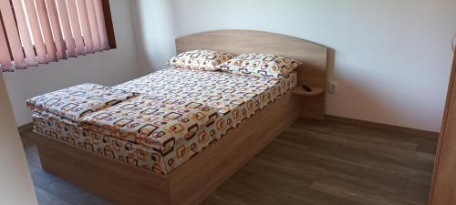 a bedroom with a bed with a wooden headboard and pillows at Apartament Betula in Sovata