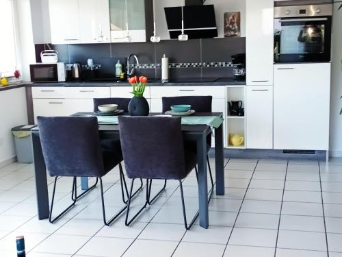 a kitchen with a black table and chairs at Ferienwohnung am Wald in Warstein