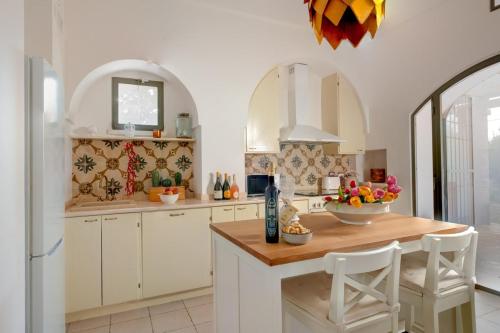 une cuisine avec des armoires blanches et un comptoir en bois dans l'établissement Antique Villa, Casa Rosa - 3 bed, 2 bath with pool, à Ceglie Messapica