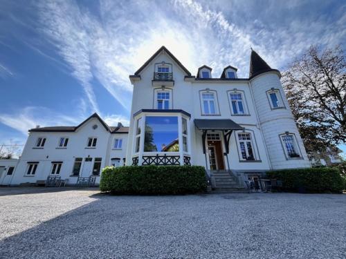 a large white house with a large window at La Villa Blanche Spa in Spa