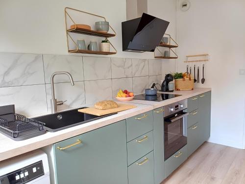 une cuisine avec un évier et une cuisinière four supérieur dans l'établissement Paul Sautai - 2 couchages - proche centre, à Amiens