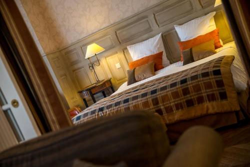 a bedroom with a large bed with a large mirror at Villa Augeval Hôtel de charme & Spa in Deauville
