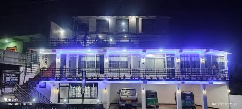 a building with two trucks parked outside at night at White House in Haputale