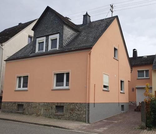 WeiselにあるHaus Zwanzigの黒屋根のオレンジ白家