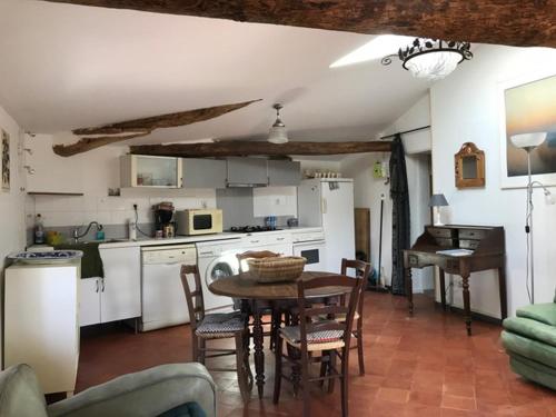 une cuisine avec une table et des chaises dans une pièce dans l'établissement Place du village Haute Provence, à Puimichel