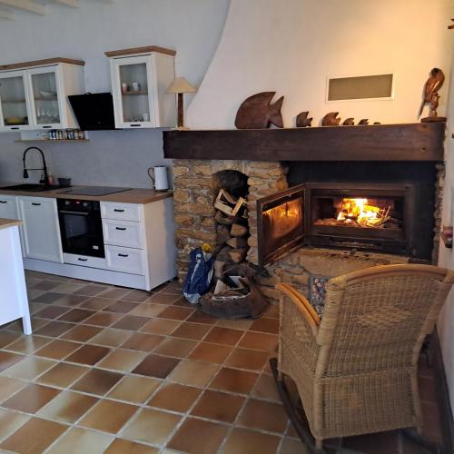 - une cuisine avec une cheminée en pierre dans l'établissement Grande maison au cœur du pays bigouden, à Plonéour-Lanvern