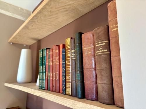 a row of books sitting on a shelf at Le cocon des Quais in Auxerre