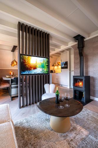 a living room with a table and a fireplace at Casa Vida Verde - Luxe vakantiewoning aan het water! in Gramsbergen