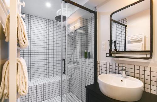 une salle de bain blanche avec un lavabo et une douche dans l'établissement Explore Local Bakeries from a Boho Artist Loft, à Paris