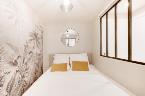 - une chambre avec des murs blancs et un lit avec deux oreillers dans l'établissement Explore Local Bakeries from a Boho Artist Loft, à Paris
