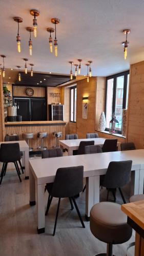 a dining room with tables and chairs in a restaurant at Les Neiges in Saint-Sorlin-dʼArves