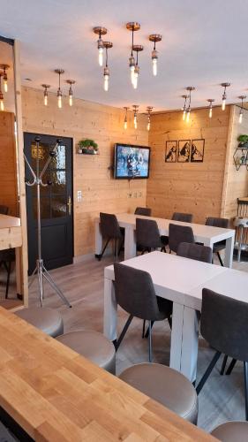 a dining room with tables and chairs and a tv at Les Neiges in Saint-Sorlin-dʼArves