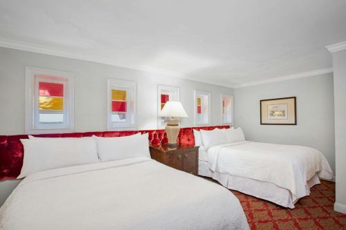 two beds in a white room with red accents at Casa Monica Resort & Spa, Autograph Collection in Saint Augustine