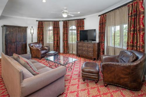 a living room with a couch and chairs and a television at Casa Monica Resort & Spa, Autograph Collection in Saint Augustine