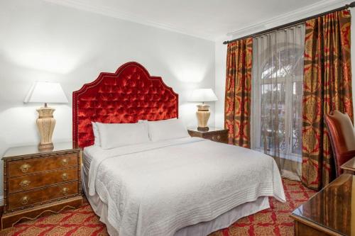 a bedroom with a large bed with a red headboard at Casa Monica Resort & Spa, Autograph Collection in Saint Augustine