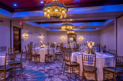 a banquet room with tables and chairs and a chandelier at Casa Monica Resort & Spa, Autograph Collection in Saint Augustine