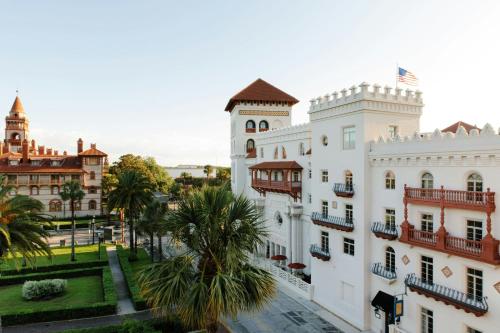 a white building with a palm tree in front of it at Casa Monica Resort & Spa, Autograph Collection in Saint Augustine