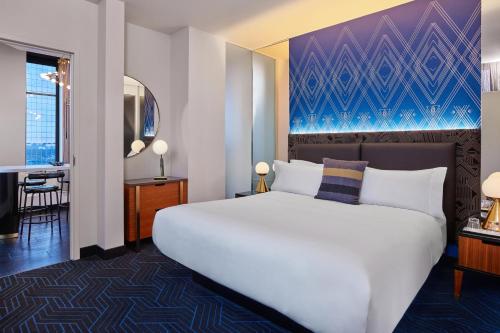 a bedroom with a large white bed and a desk at W Minneapolis - The Foshay in Minneapolis