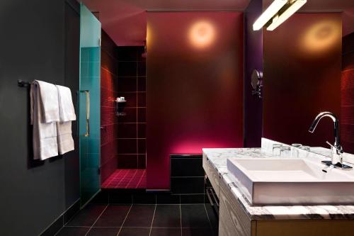 a bathroom with a sink and a red shower at W Minneapolis - The Foshay in Minneapolis