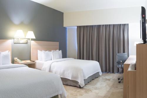 Ένα ή περισσότερα κρεβάτια σε δωμάτιο στο Courtyard by Marriott Villahermosa Tabasco