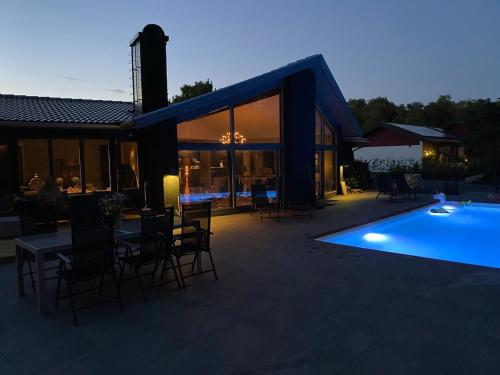 a swimming pool in front of a house at Delicious pool villa near Tylösand in Halmstad
