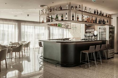 a bar in a restaurant with tables and chairs at AC Hotel by Marriott St Julian's in St Julian's