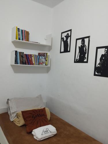 a room with a bed with a book shelf and some pictures at Studio 202 Cop 30 in Belém