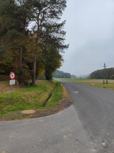 an empty road with a speed limit sign on the side at Ferienwohnung Waldblick, nahe Jennersdorf und Therme in Windisch Minihof