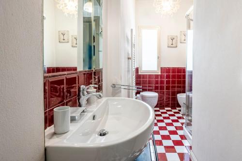 a bathroom with a white sink and a red tiled floor at Old Town, near Ponte Vecchio in Florence